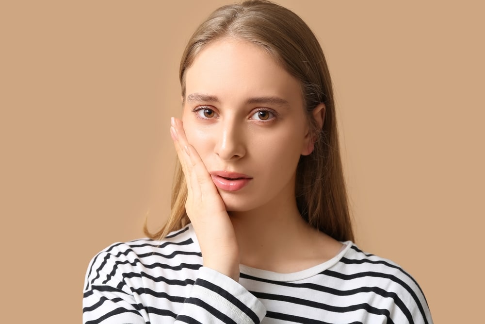 Douleur_Dentaire_Causes_Urgence_Dentiste_Laval Une jeune femme a une douleur dentaire